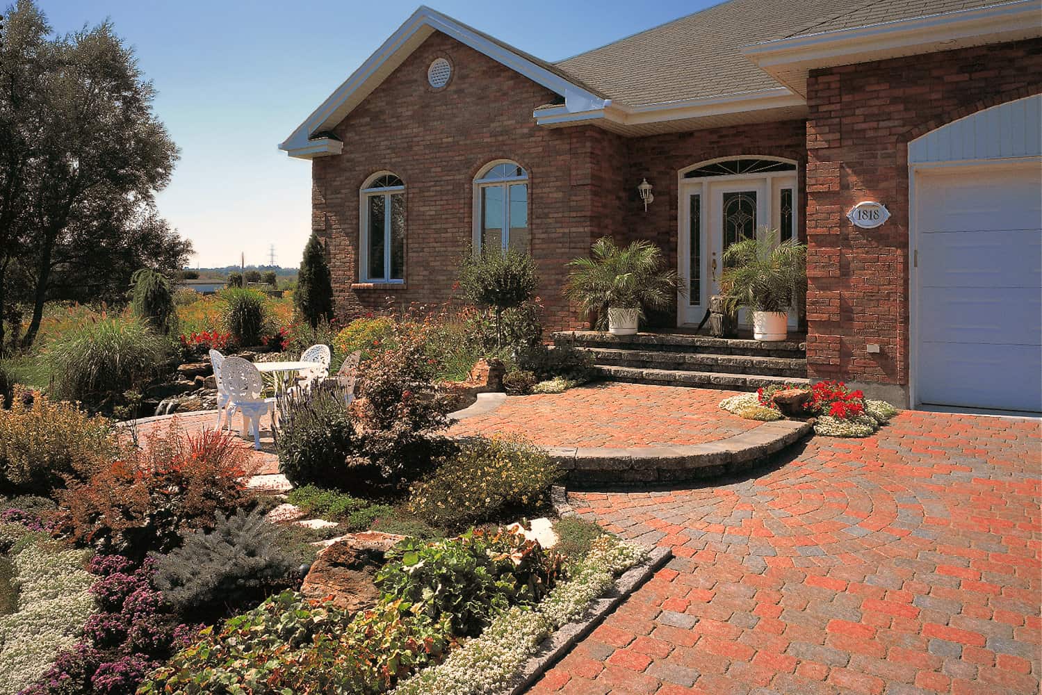 Brick Home with Paving Stone Driveway with Table and Chairs Landscape
