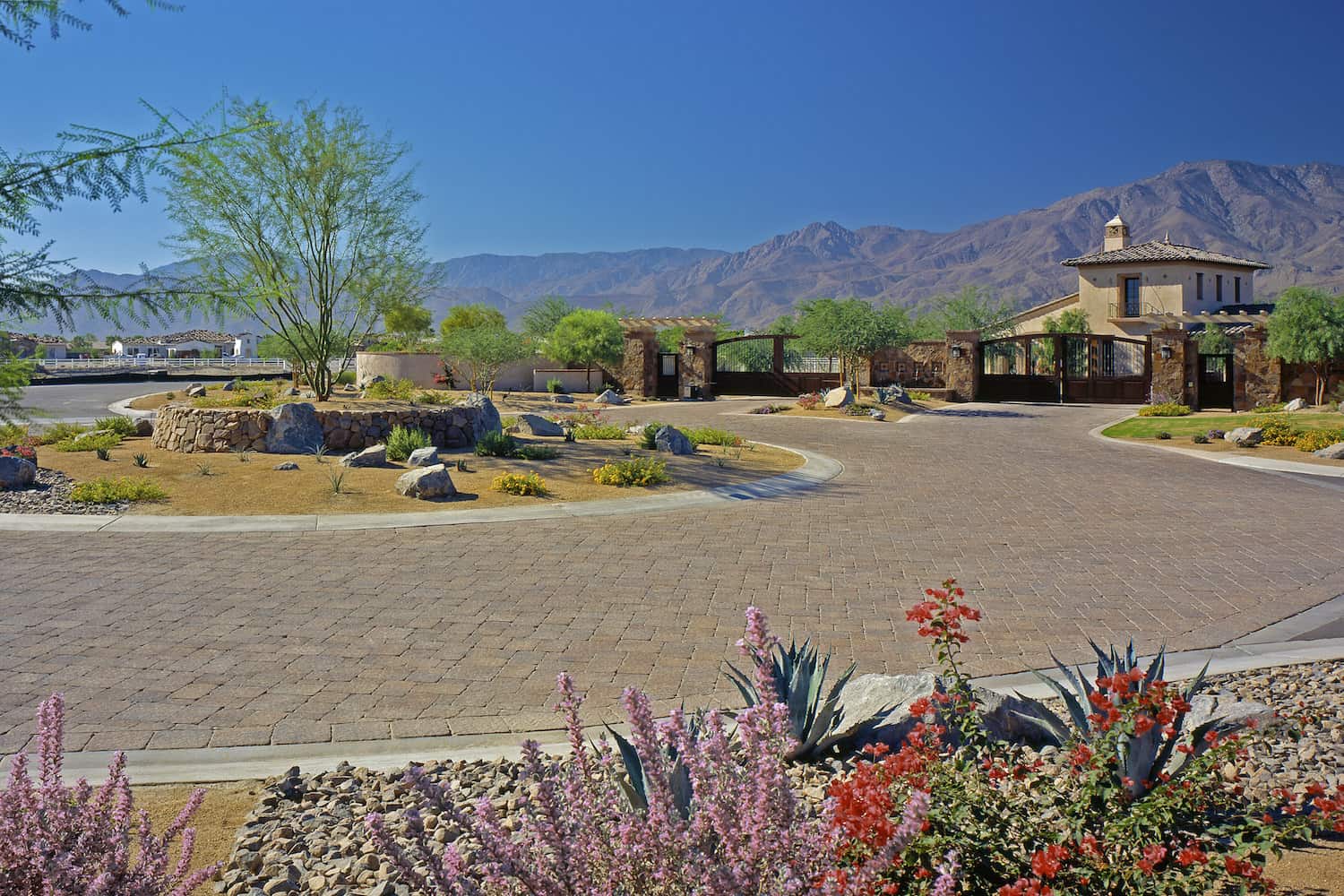 Circular Paving Stone Landscape with Home Behind Gate