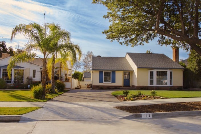 Paving Stone Driveway in Front of a Yellow House and Lawn