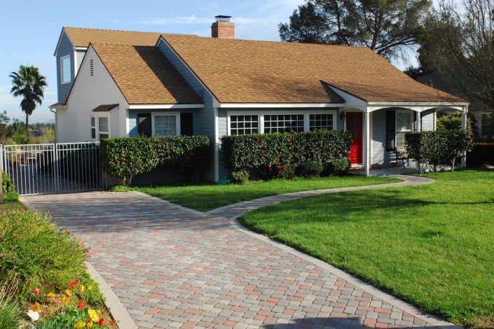 Paving Stone Multi Colored Driveway and a Home with a Red Door