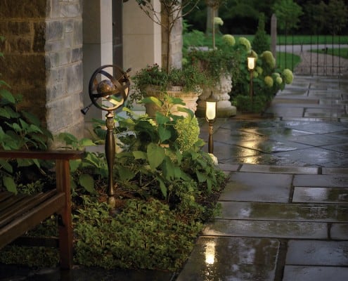 Lit paving stone path with decorative plants