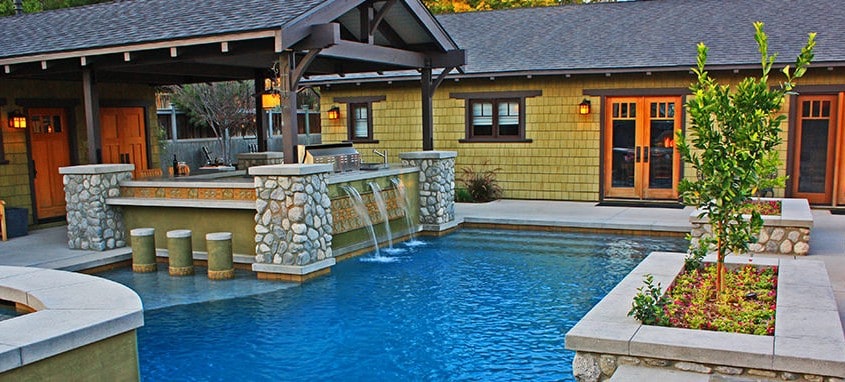 pool with waterfall and outdoor kitchen
