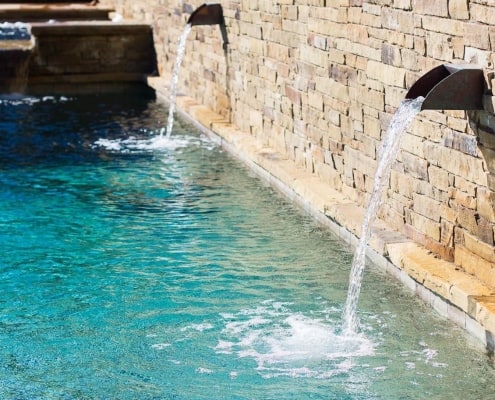 water falls feature with paving stone wall on pool design