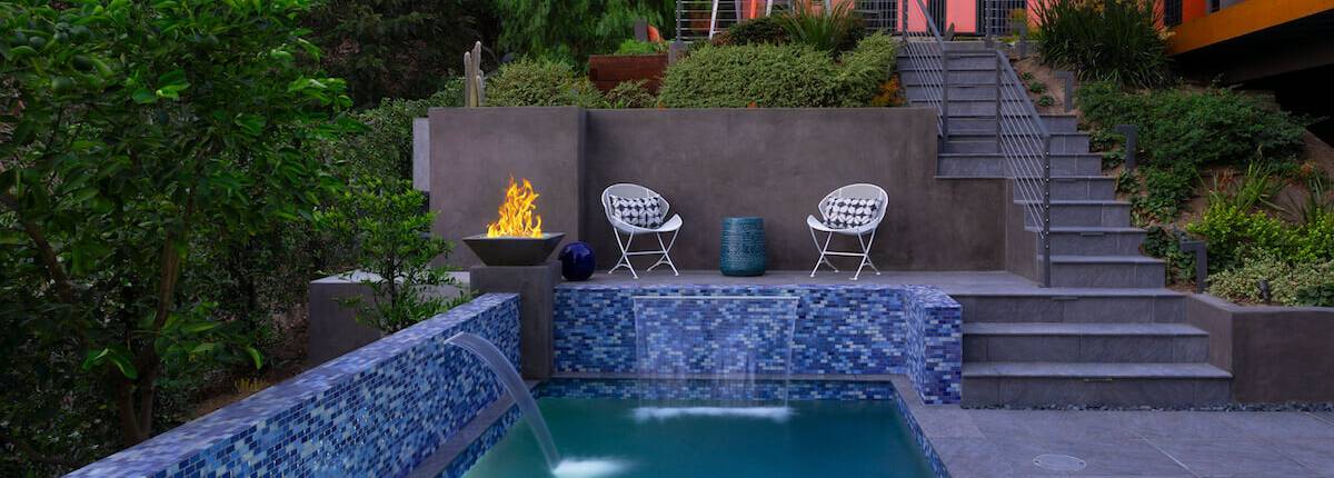 Modern pool with fire feature and waterfall